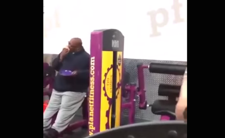 Guy eating pizza while working out