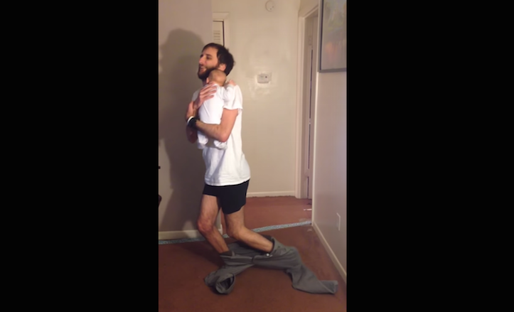 Puttings pants on holding baby